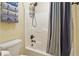 Bright bathroom features a shower with sleek fixtures and stylish striped shower curtain at 959 Cedar Falls Sw Ct, Lilburn, GA 30047
