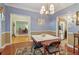 Elegant dining room boasts hardwood floors, a modern chandelier, and opens to other rooms at 959 Cedar Falls Sw Ct, Lilburn, GA 30047