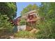 Charming home featuring a large deck with railings and lush, mature landscaping at 959 Cedar Falls Sw Ct, Lilburn, GA 30047