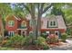 Beautiful two-story brick home with mature trees, lush landscaping, and a circular driveway at 959 Cedar Falls Sw Ct, Lilburn, GA 30047
