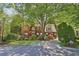 Stately brick home with lush landscaping, mature trees, and a long driveway at 959 Cedar Falls Sw Ct, Lilburn, GA 30047