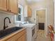 Well-lit laundry room featuring a modern washer and dryer, stylish sink, and functional storage solutions at 959 Cedar Falls Sw Ct, Lilburn, GA 30047