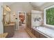 Main bathroom with double sink vanity, a soaking tub and glass-enclosed shower at 959 Cedar Falls Sw Ct, Lilburn, GA 30047