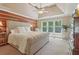 Spacious main bedroom featuring a wood accent wall, tray ceiling, and lots of natural light at 959 Cedar Falls Sw Ct, Lilburn, GA 30047