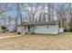 Single-story home with light green siding, a covered front porch with stairs, and a partially wooded front yard at 2366 Forrest Park Se Rd, Atlanta, GA 30315