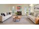 Bright, staged living room with white sofas, fireplace, and striped rug at 5084 Brittany Dr, Stone Mountain, GA 30083