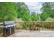 Back deck with grill, a variety of potted plants, and a view of the lush green backyard at 830 Montego Sw Way, Lilburn, GA 30047