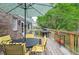 Back deck with outdoor dining set, umbrella, grill, and wooded backyard at 830 Montego Sw Way, Lilburn, GA 30047