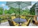 Back deck with outdoor dining set, umbrella, landscaping, and a serene view of the lush green backyard at 830 Montego Sw Way, Lilburn, GA 30047