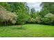 A spacious backyard features a lush green lawn surrounded by mature trees at 830 Montego Sw Way, Lilburn, GA 30047