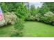 A spacious backyard features a lush green lawn surrounded by mature trees at 830 Montego Sw Way, Lilburn, GA 30047