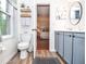 Bathroom with gray cabinets, wood floors, a toilet, and a view into the bedroom at 830 Montego Sw Way, Lilburn, GA 30047