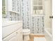 Bathroom features white vanity, floral wallpaper, and natural light from the window at 830 Montego Sw Way, Lilburn, GA 30047