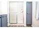 Bathroom with a shower and frosted glass doors and gray cabinet at 830 Montego Sw Way, Lilburn, GA 30047