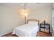 Bedroom with hardwood floors, white comforter, neutral walls, ceiling fan, and natural light at 830 Montego Sw Way, Lilburn, GA 30047