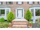 Charming brick entryway with a white front door, complemented by decorative plants and lush greenery at 830 Montego Sw Way, Lilburn, GA 30047