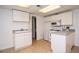 Simple kitchenette with white cabinets and appliances offering functionality and convenience at 830 Montego Sw Way, Lilburn, GA 30047