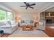 Comfortable living room with hardwood floors, a bay window, and a brick fireplace with built-in shelving at 830 Montego Sw Way, Lilburn, GA 30047
