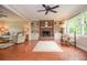 Bright living room with hardwood floors, a brick fireplace, and large windows, offering a warm and inviting ambiance at 830 Montego Sw Way, Lilburn, GA 30047