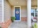 Front entrance with a blue door and a spring flower wreath at 537 Daffodil Ln, Mcdonough, GA 30253