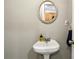 Simple bathroom with pedestal sink and a round mirror at 771 Jordan Ln # F, Decatur, GA 30033