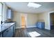 Bright kitchen with gray cabinets, granite countertops, and a view to another room at 3 Bay St, Covington, GA 30014