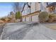 Three-car garage with stone facade and a long driveway at 610 Lovinggood Trl, Woodstock, GA 30189