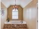 Bathroom showing bathtub with tile base and decorative chandelier at 1095 Whitehawk Trl, Lawrenceville, GA 30043