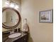 Bathroom featuring dark vanity with granite top, round mirror, and framed lighthouse image at 1095 Whitehawk Trl, Lawrenceville, GA 30043