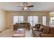 Inviting living room featuring neutral tones, ceiling fan, and large windows offering ample natural light and a cozy feel at 1095 Whitehawk Trl, Lawrenceville, GA 30043