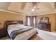 Main bedroom featuring a ceiling fan and tray ceiling, as well as a dark wood dresser and nightstand at 1095 Whitehawk Trl, Lawrenceville, GA 30043