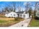 A well maintained home with white siding and black trim next to a paved driveway at 1380 Westmont Sw Rd, Atlanta, GA 30311