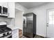 Kitchen with stainless steel refrigerator and range, white cabinets, and hardwood floors at 1380 Westmont Sw Rd, Atlanta, GA 30311