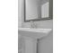 Elegant pedestal sink with a gray framed mirror in a modern bathroom at 4131 Fulson Dr, Lilburn, GA 30047