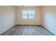 Cozy bedroom featuring wood-look flooring, neutral-painted walls, and ample natural light from a window at 1119 Summer Brook Rd, Atlanta, GA 30349