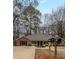Charming single-story home with brick and olive green accents, surrounded by mature trees and a spacious driveway at 1119 Summer Brook Rd, Atlanta, GA 30349