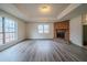 Bright living room featuring a brick fireplace, large windows, and elegant gray wood flooring at 1119 Summer Brook Rd, Atlanta, GA 30349