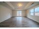 A spacious living room with large windows that bring in plenty of natural light and modern gray laminate flooring at 1119 Summer Brook Rd, Atlanta, GA 30349