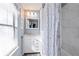 Bathroom with white vanity, framed mirror, shower/tub combo with white tile and window blinds at 2492 Crumps Landing Cir, Snellville, GA 30039