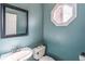 Stylish powder room with blue walls, octagon window, and sleek fixtures at 2107 Kendall Close Nw, Acworth, GA 30102