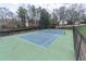 View of tennis court surrounded by green space and trees at 2107 Kendall Close Nw, Acworth, GA 30102