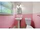 Small bathroom with pink tile and pedestal sink at 241 W Simon Nw Ter, Atlanta, GA 30318