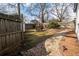 Large fenced-in backyard with a stone pathway, dining set, storage shed, and lawn lighting at 953 Garibaldi Sw St, Atlanta, GA 30310