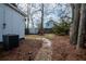 Landscaped backyard with stone pathway, patio furniture, storage shed, and mature trees at 953 Garibaldi Sw St, Atlanta, GA 30310