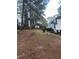 Large backyard with mature trees and sloped terrain at 911 David Dr, Lawrenceville, GA 30046