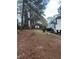Sloped backyard with pine trees and wooden fence at 911 David Dr, Lawrenceville, GA 30046