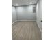 Finished basement room with gray walls and wood-look floors at 911 David Dr, Lawrenceville, GA 30046