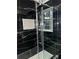 Modern bathroom with black marble tile and glass shower at 911 David Dr, Lawrenceville, GA 30046