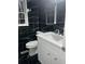Updated bathroom featuring black tile and a white vanity at 911 David Dr, Lawrenceville, GA 30046