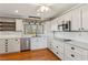Updated kitchen boasts white cabinets, stainless steel appliances, and hardwood floors at 213 Pine Crest Dr, Cumming, GA 30040
